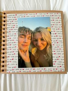 two people are posing in front of a photo book with hearts on it and the words i love you