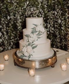 a wedding cake with white flowers and candles