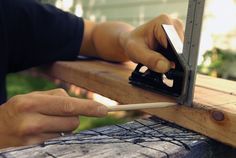 a person using a circular saw to cut through a piece of wood on a bench