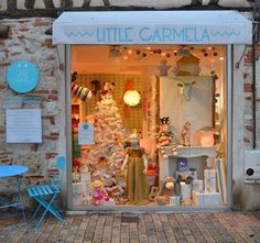 there is a little carmela store front with its windows decorated for the holiday season