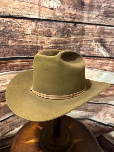 vintage Stetson,  from the mid-20th century, judging by the craftsmanship and the style of the branding. The hat features a light tan or camel-colored felt, a classic wide brim, and a matching hatband. The interior shows the iconic Stetson logo printed on the lining, with an image that appears to be of a cowboy scene, which is common in many vintage Stetson hats. The hat also has leather sweatband detailing. ### Key Features: - **Brand Stetson - **Material Likely a high-quality fur felt, possibl Cowboy Scene, Stetson Hats, Stetson Hat, Golden Tan, Light Tan, Hat Band, Cowboy Hat, Wide Brimmed, Etsy Vintage