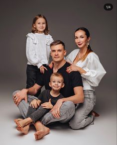 a family posing for a photo in front of a gray background