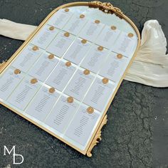 a table plan sitting on the ground next to a piece of paper with gold foil