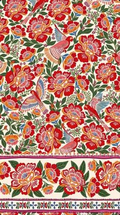 an intricately designed red and green floral design on white fabric with pink, blue, orange