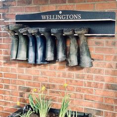 a brick wall with several rain boots hanging on it