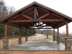 an outdoor covered parking lot with stone pillars