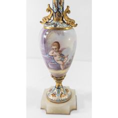 an ornate vase with a cherub painted on it