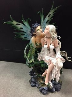 a figurine of a woman kissing a man with wings on top of it