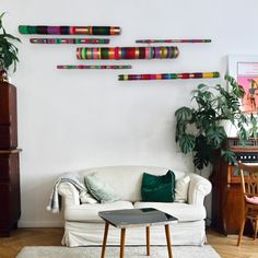 a living room filled with furniture and lots of colorful sticks on the wall above it