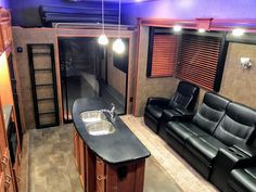 the interior of a motor home with leather couches and kitchenette in it,