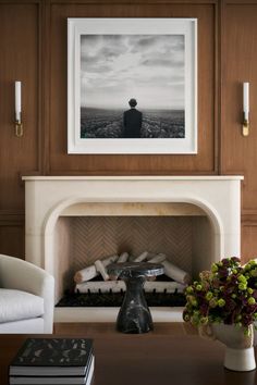 a living room filled with furniture and a fire place in front of a painting on the wall