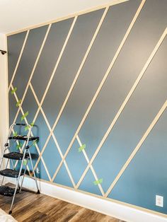 a ladder leaning against a wall painted with blue and white geometric lines on the wall