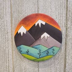 a painted mountain scene on the side of a wooden fence