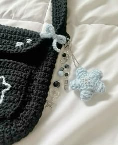 there is a crocheted bag with a keychain attached to it on the bed