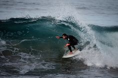 a man riding a wave on top of a surfboard