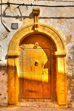 an old wooden door in front of a stone wall