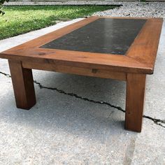 a wooden table sitting on top of a cement ground