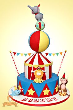 a circus themed birthday cake with animals on top, and an elephant sitting on top