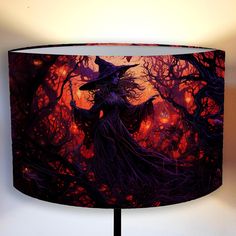 a lamp shade with an image of a witch holding a staff in the woods at night