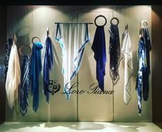 several different types of scarves hanging on the wall