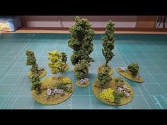 several small trees and rocks on a blue table with green flooring in the background