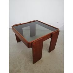 a glass and wood coffee table sitting on the floor