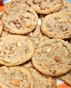 a plate full of cookies with nuts on top and an orange striped napkin behind it