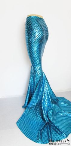 a blue mermaid costume is on display in front of a white wall