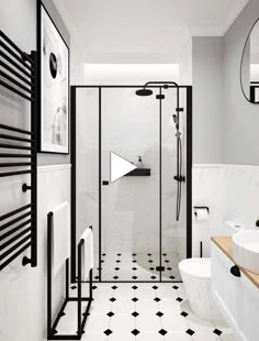 a bathroom with black and white tile flooring and walls, along with a walk in shower