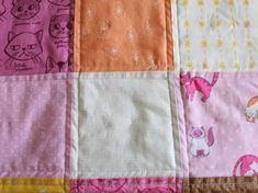 a patchwork quilt with cats and other animals on pink, orange, yellow and white squares