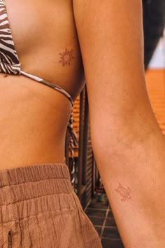 a close up of a person's arm with a small tattoo on her left side