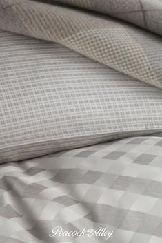 the bed is made up with grey and white checkered sheets