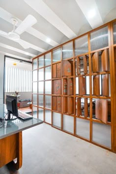 an office with glass partitions and wooden furniture