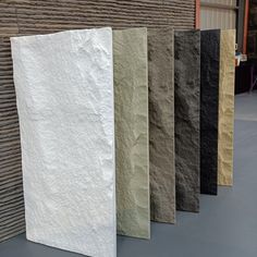 five different colored stone slabs lined up against a wall