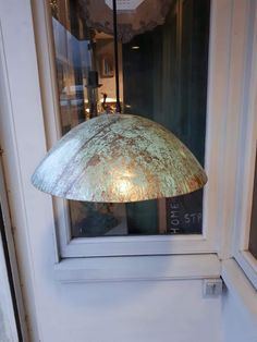 an old light hanging from the side of a window