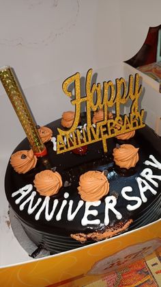 a black and gold happy anniversary cake in a box with the word'happy anniversary'on it