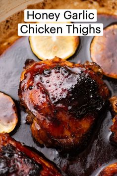 honey garlic chicken thighs in a pan with lemons and sauce on the side for garnish