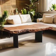 a wooden table sitting on top of a white couch in a living room next to potted plants