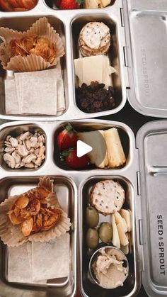 an open lunch box filled with different types of food and snacks, including crackers