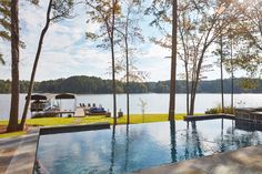 an outdoor swimming pool surrounded by trees and water