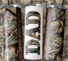 two camo travel mugs with the word dad printed on them next to each other