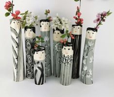 several vases with flowers in them sitting next to each other on a white surface