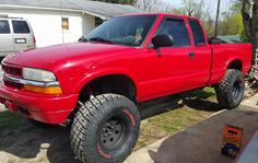 a red pick up truck parked in front of a house