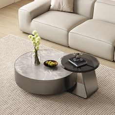 a living room with a couch, coffee table and vase on the floor in front of it