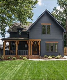 a blue house is shown in the middle of a green yard with trees and grass