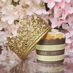 an ornate gold box sitting on top of a table next to some pink and white flowers