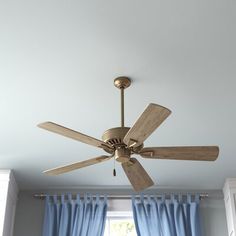 a ceiling fan in a room with blue curtains