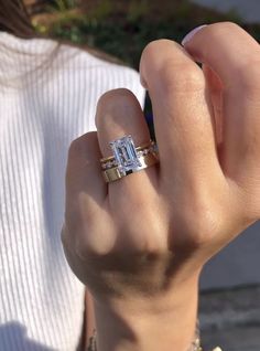 a woman is holding up her engagement ring