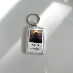 a keychain with an image of a person in the background on a white surface