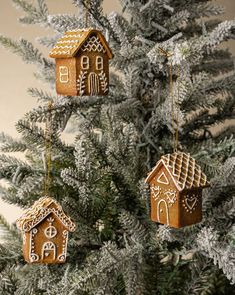 three gingerbread houses hanging from a christmas tree